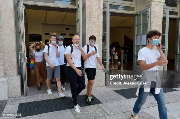 Young students wearing protective masks leaving a school after the first day of class on Liceo Da Vinci of Trento on September 14, 2020 in Trento,...