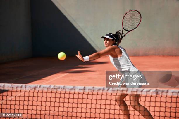 femme adulte jouant le tennis professionnel sur le court de terre battue - tennis woman photos et images de collection