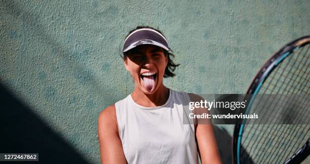 potrait de joueur de tennis féminin souriant avec la langue dehors - tennis woman photos et images de collection