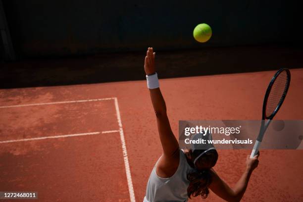 tennista professionista che serve palla durante la partita - tennis foto e immagini stock