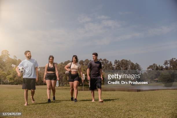 friends playing football in the park. - brazilian playing football stock pictures, royalty-free photos & images
