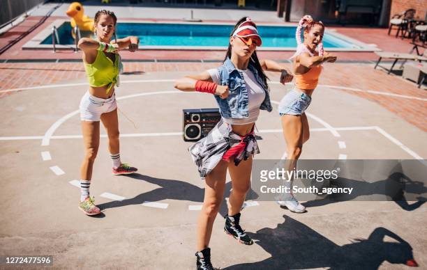 drei moderne tänzerinnen tanzen gemeinsam am pool - besatzung stock-fotos und bilder