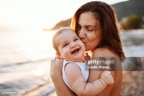 body positive mother enjoying summer holiday with baby girl. baby is laughing and looking into camera - 35 39 years stock pictures, royalty-free photos & images