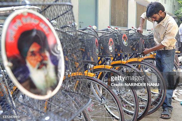 Indian cycle mechanics fix new bicycles at a government school in Amritsar on September 25, 2011. The Punjab state distributed free bicycles to all...