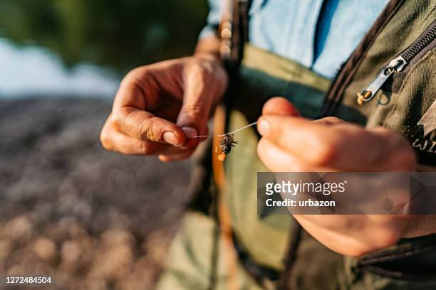 fisherman setting fly as bait - fishing bait stock pictures, royalty-free photos & images