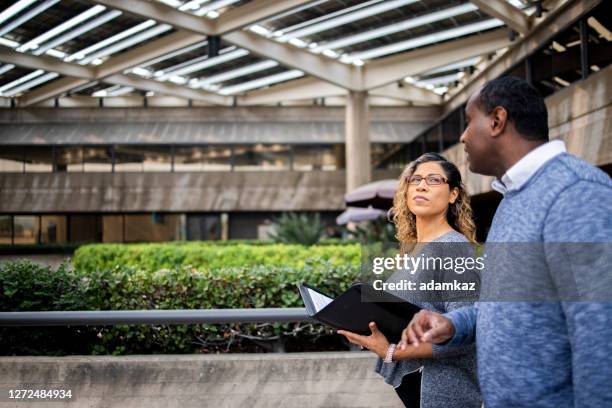 diverse coworkers discussing issues while walking - americas role in promoting democracy and human rights stock pictures, royalty-free photos & images