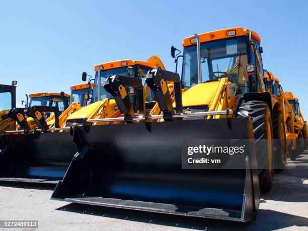 parked diggers in a row - construction vehicle stock pictures, royalty-free photos & images