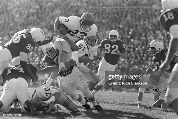 An unknown Kansas Jayhawks player hurdles Lyle Sittler of the Nebraska Cornhuskers on November 9, 1963 in Lincoln, NE.