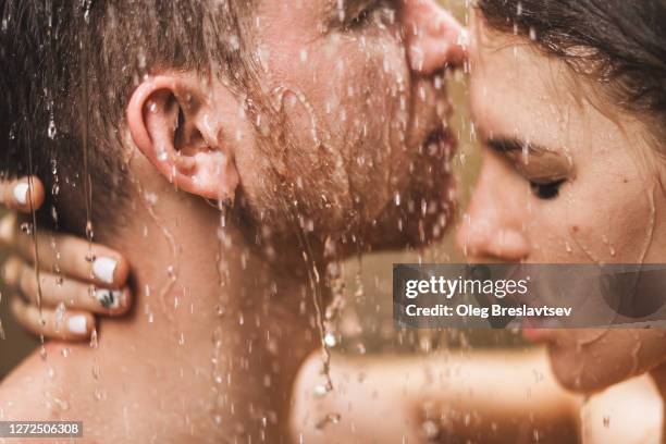 close up portrait of couple in love kissing under tropical shower with passion. intimate, togetherness and romantic. - couples kissing shower photos et images de collection