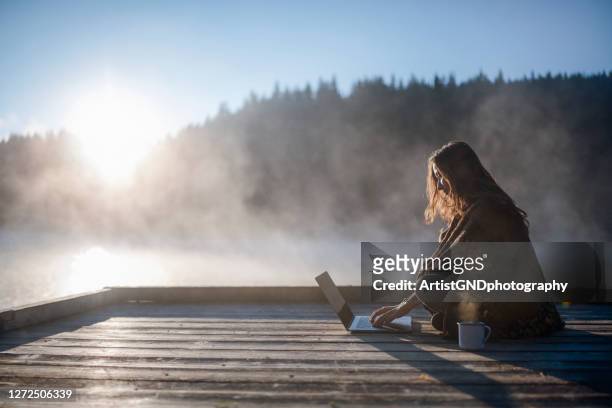 woman relaxing in nature and using technology. - freedom stock pictures, royalty-free photos & images