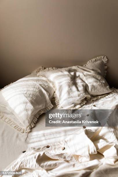 empty white linen bedding set with ruffle pillows in morning shining sunlight. - bettbezug stock-fotos und bilder