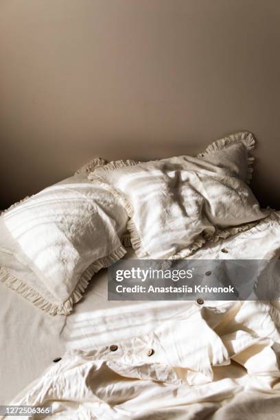 empty white linen bedding set with ruffle pillows in morning shining sunlight. - froncé photos et images de collection