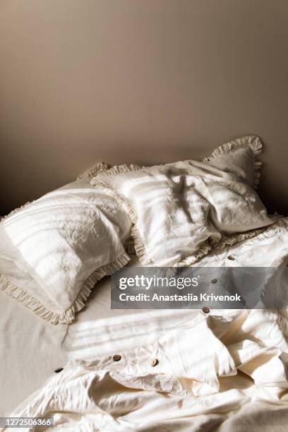 empty white linen bedding set with ruffle pillows in morning shining sunlight. - sleep hygiene stock pictures, royalty-free photos & images