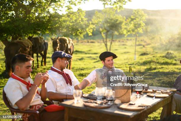 entspannte argentinische gauchos am ende der mittags-asado-mahlzeit - asado stock-fotos und bilder