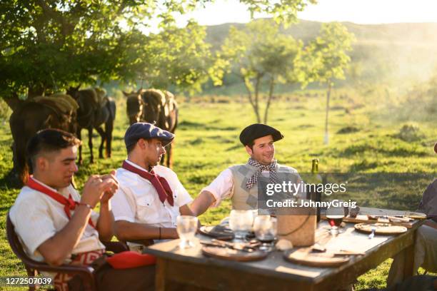 gauchos argentini rilassati alla fine del pasto asado di mezzogiorno - gaucho foto e immagini stock