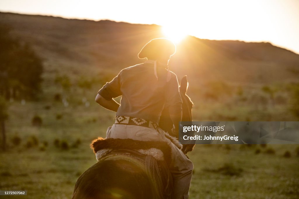 Young gaucho on horseback in late afternoon