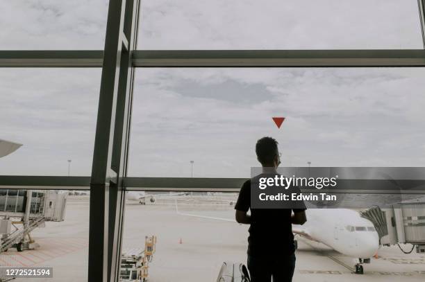 asian chinese traveller in airport observing social distancing with face mask - kuala lumpur airport stock pictures, royalty-free photos & images