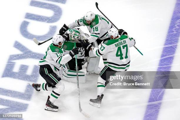 Jason Dickinson, Alexander Radulov and Mattias Janmark of the Dallas Stars grab on to Anton Khudobin as they celebrate their 3-2 overtime victory...