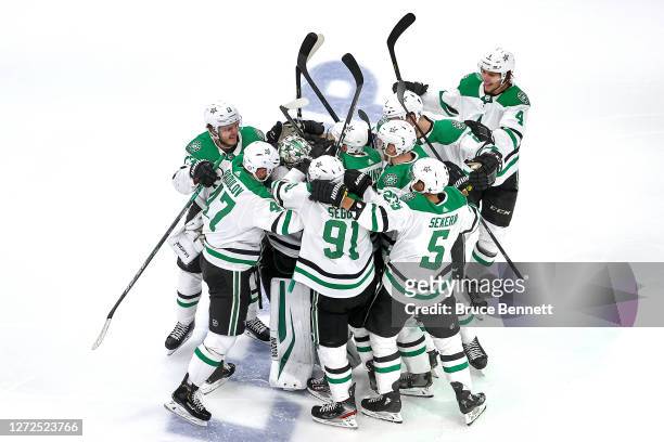 Anton Khudobin of the Dallas Stars is surrounded by his teammates as they celebrate their 3-2 overtime victory against the Vegas Golden Knights to...