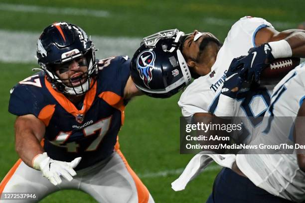 Josey Jewell of the Denver Broncos pulls the helmet off of Dalyn Dawkins of the Tennessee Titans during the second half of Tennessee's 16-14 win on...