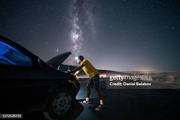 car repair with the milky way on the background. lucky me. lost with a broken car in the middle of nowhere at night. diy - roadside challenge stock pictures, royalty-free photos & images