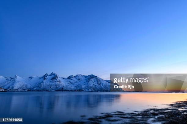 schneebedeckter winterlandschaft sonnenuntergang auf den lofoten in norwegen - fjord stock-fotos und bilder