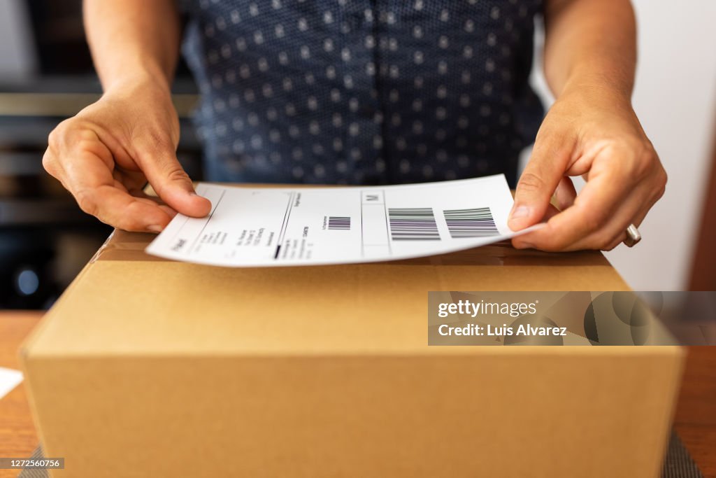 Woman preparing package for online delivery