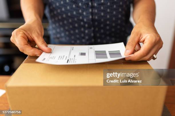 woman preparing package for online delivery - bulto fotografías e imágenes de stock