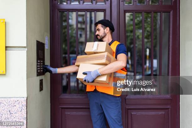 delivery man doing home delivery of online order - repartidor fotografías e imágenes de stock
