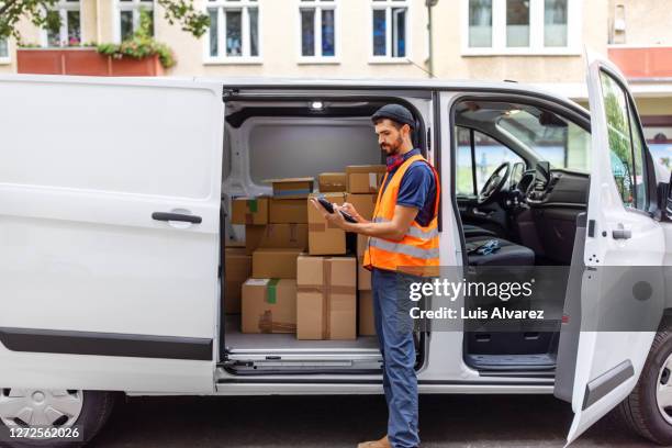 delivery man using digital tablet by van - vehicle door stock pictures, royalty-free photos & images