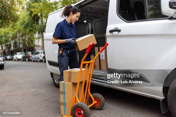 delivery person checking the boxes and loading on a hand cart - sackkarre stock-fotos und bilder