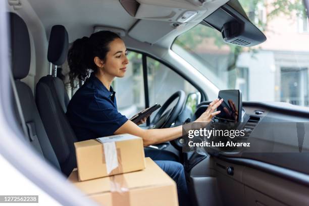 delivery person using car gps to determine customer's address - veicolo terrestre commerciale foto e immagini stock