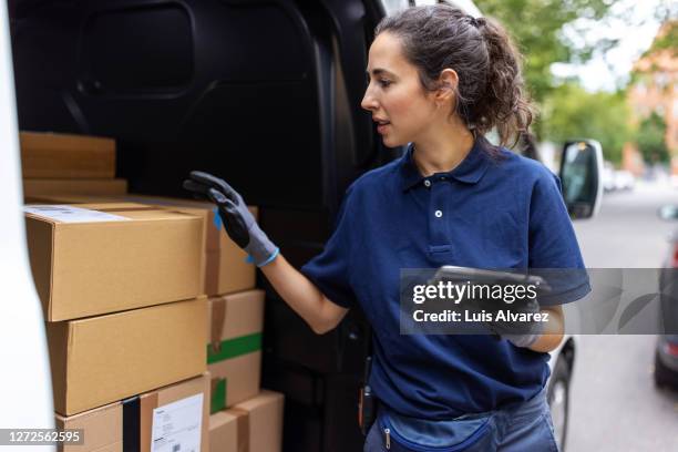 courier checking the parcel for delivery in the van - blue polo shirt photos et images de collection