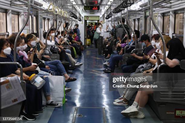 South Koreans wear masks on a subway as South Koreans take measures to protect themselves against the spread of coronavirus pandemic on September 15,...