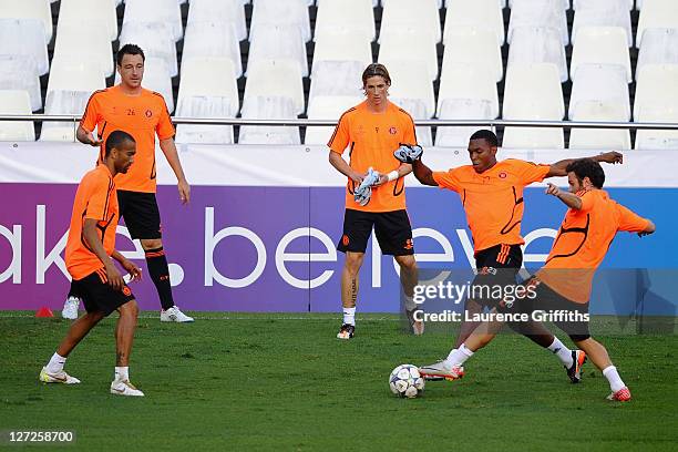 Juan Mata of Chelsea tackles team mate Daniel Sturridge as Jose Bosingwa, John Terry and Fernando Torres look on during a training session ahead of...