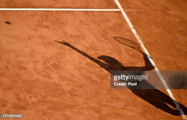 Shadow is seen on the court as Guido Pella of Argentina serves in his round one match against Denis Shapovalov of Canada during day two of the...
