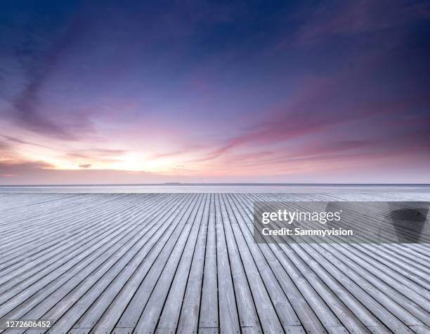 wooden parking lot against seaside during sunset - dusk stock pictures, royalty-free photos & images