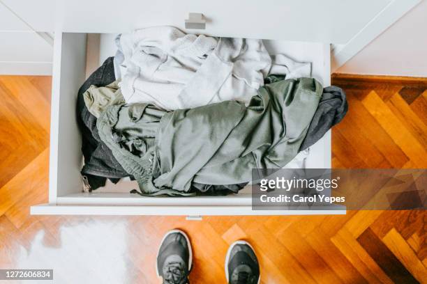 pov one person standing in front of messy dresser drawer - chaotic system people foto e immagini stock