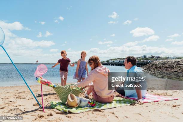 making the most of the sunshine - uk beach stock pictures, royalty-free photos & images