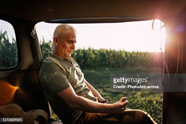 mittlerer erwachsener landwirt inspiziert sein land - autobauer stock-fotos und bilder