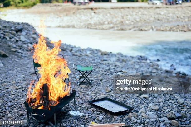 the flame of the barbecue burning beside the river - riverbed ストックフォトと画像