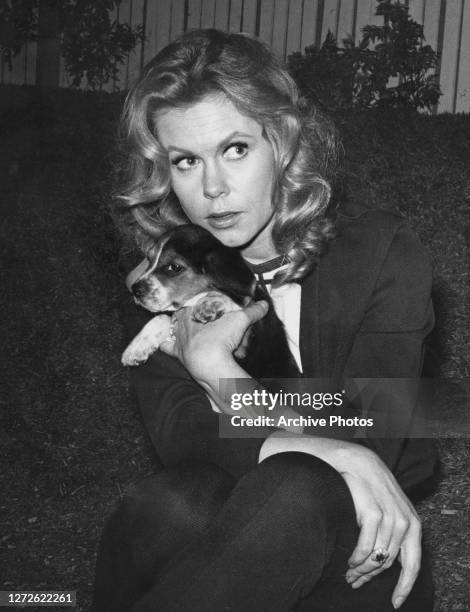 American actress Elizabeth Montgomery holding a Beagle puppy, circa 1970.