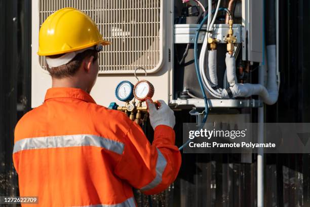 asian man technician repairing air conditioner safety uniform, technician vacuum pump evacuates and checking install new air conditioner. - sistema de calefacción ventilazión y aire acondicionado fotografías e imágenes de stock