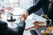 Lawyer who provides legal advice in the office. Businessman and lawyer shaking hands.