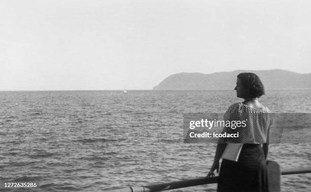 1930. alassio ligurië italië. jonge vrouw die op de kustlijn stelt - 30 40 woman stockfoto's en -beelden