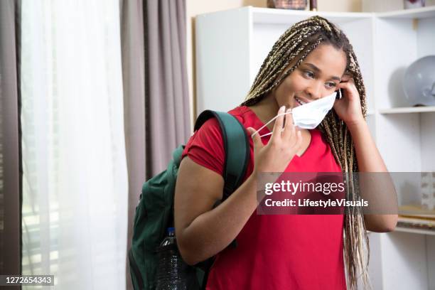college student in dorm room carrying backpack. - red blouse stock pictures, royalty-free photos & images