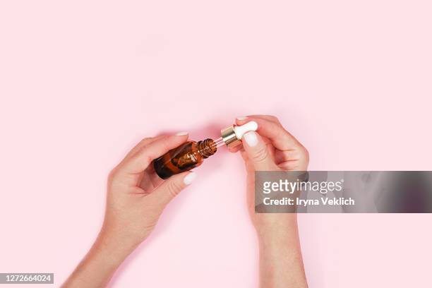 natural serum or oil in woman's hands. - nagelhaut stock-fotos und bilder