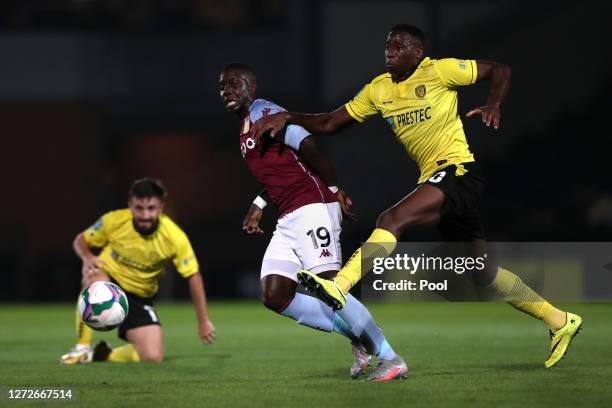 Marvelous Nakamba of Aston Villa battles for possession with Lucas Akins of Burton Albion during the Carabao Cup Second Round match between Burton...