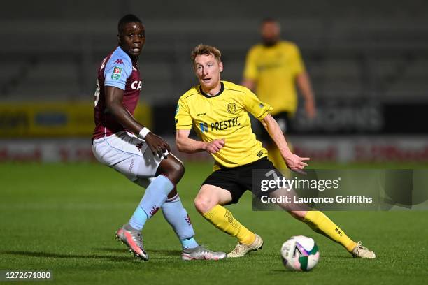 Marvelous Nakamba of Aston Villa and Stephen Quinn of Burton Albion battle for the ball during the Carabao Cup Second Round match between Burton...