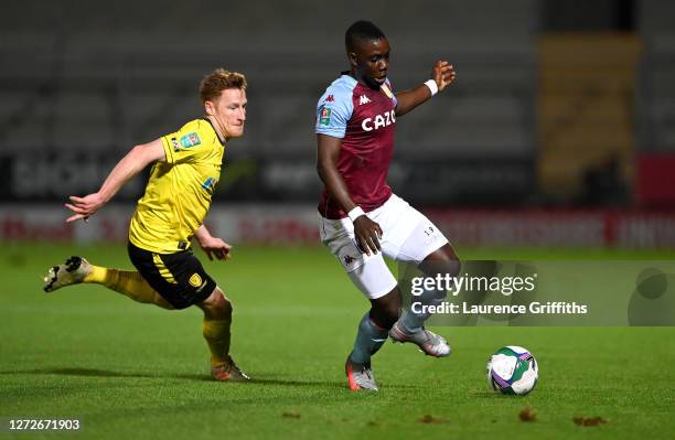 Marvelous Nakamba of Aston Villa and Stephen Quinn of Burton Albion battle for the ball during the Carabao Cup Second Round match between Burton...